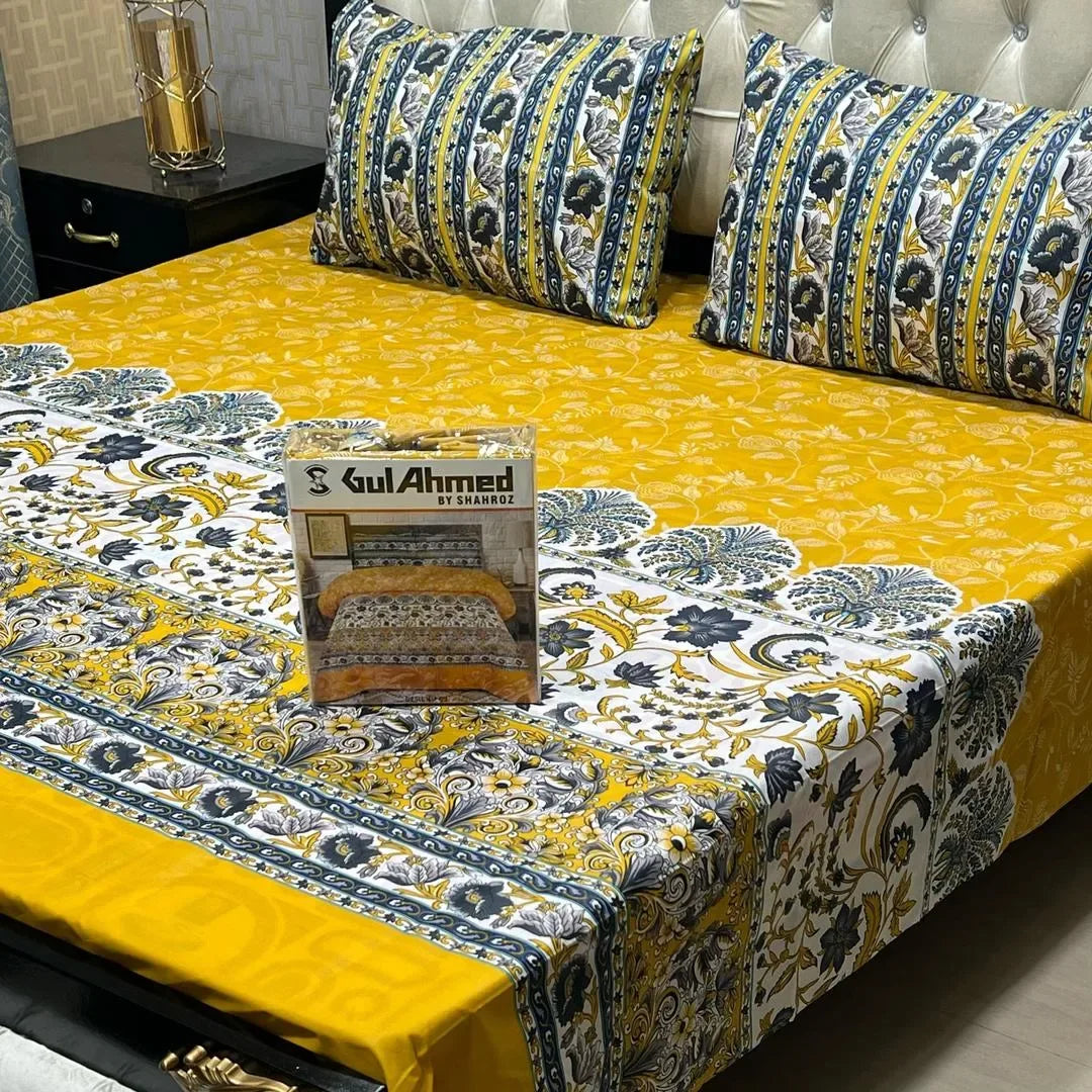 Floral-patterned bedspread on a bed with a box of Gul Ahmed on top, in a bedroom setting.