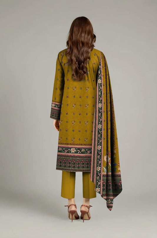 Woman wearing a mustard yellow traditional outfit with a patterned dupatta on a plain background