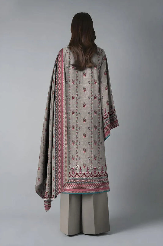 Woman wearing a traditional outfit with a patterned dupatta on a plain background