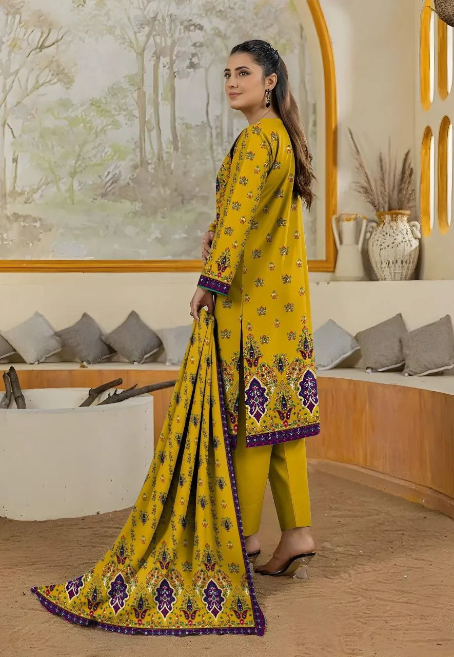 Woman in a yellow traditional outfit with floral patterns in an indoor setting.