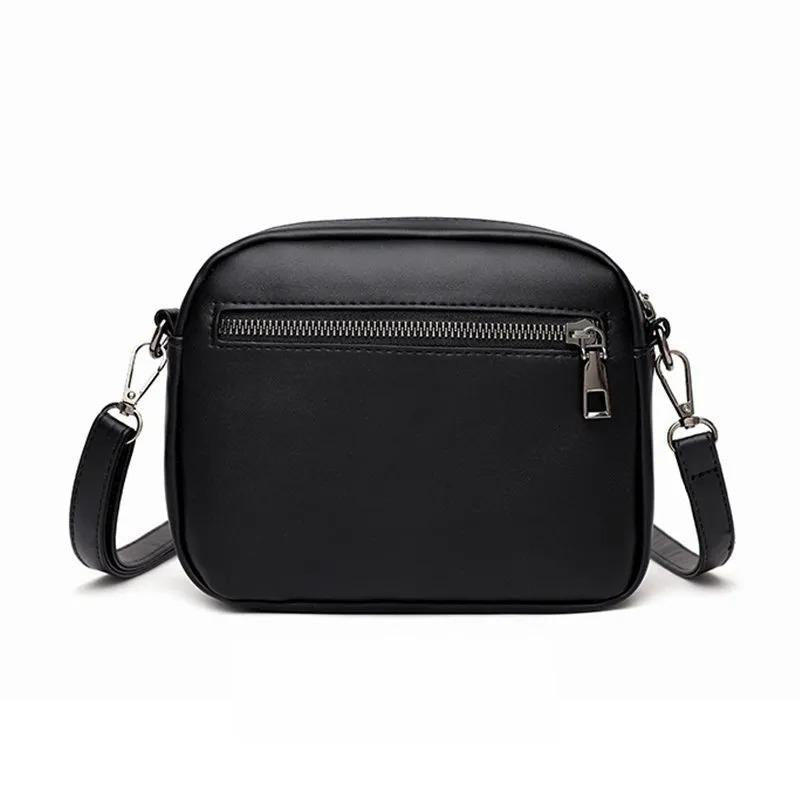 Black crossbody bag with zippers on a white background