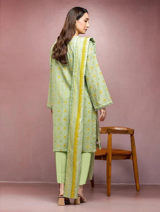 Woman wearing a green and yellow traditional outfit against a pink background