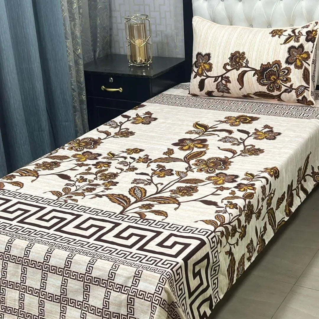 Floral patterned bedspread on a bed with matching pillow in a bedroom setting.