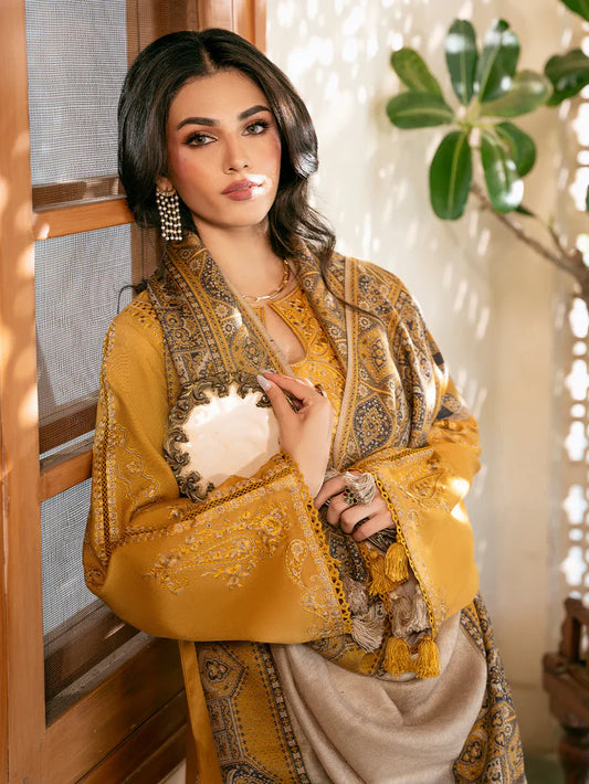 Woman wearing a yellow and gold embroidered traditional outfit indoors.