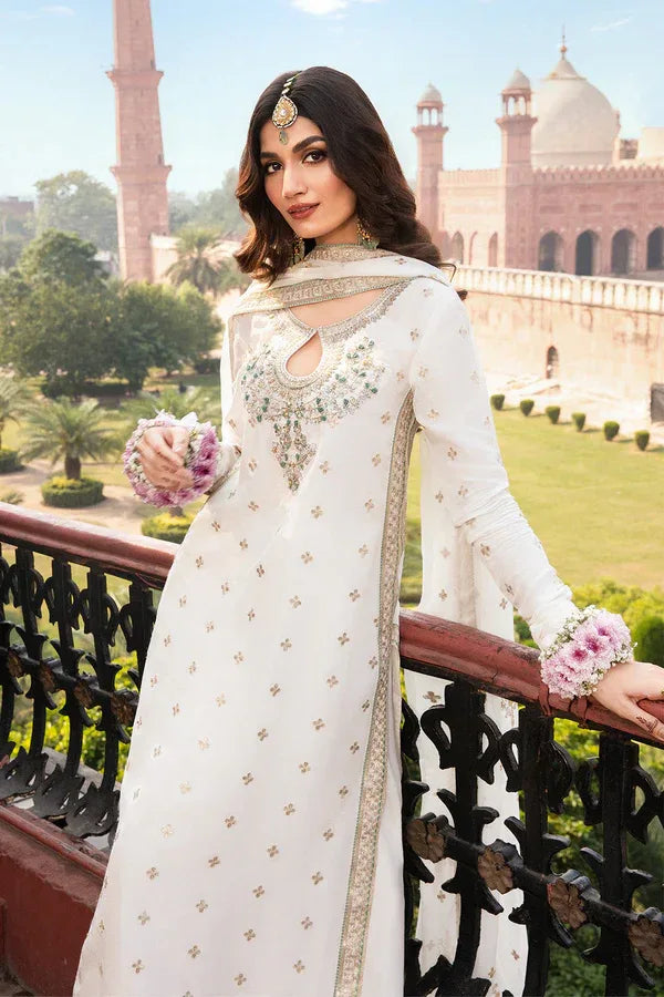 Woman in a white embroidered outfit with floral accessories standing in front of a historical building.