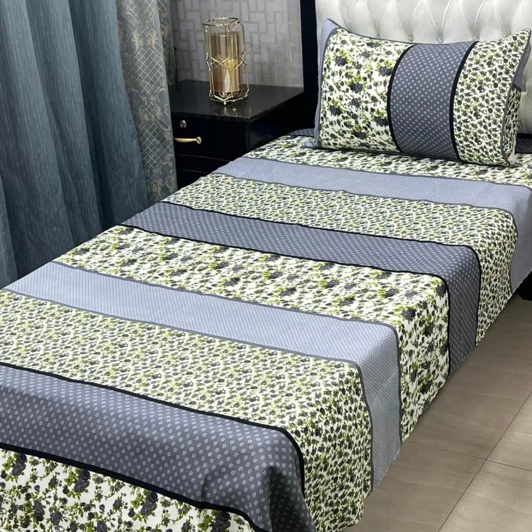 Bed with green and gray patterned bedding in a bedroom setting.
