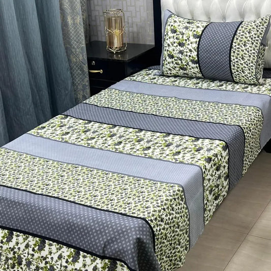 Bed with green and gray patterned bedding in a bedroom setting.