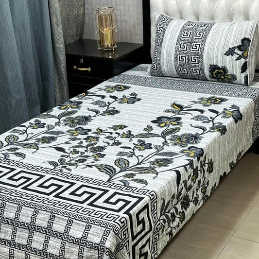 Bed with floral and geometric patterned bedspread in a bedroom setting.