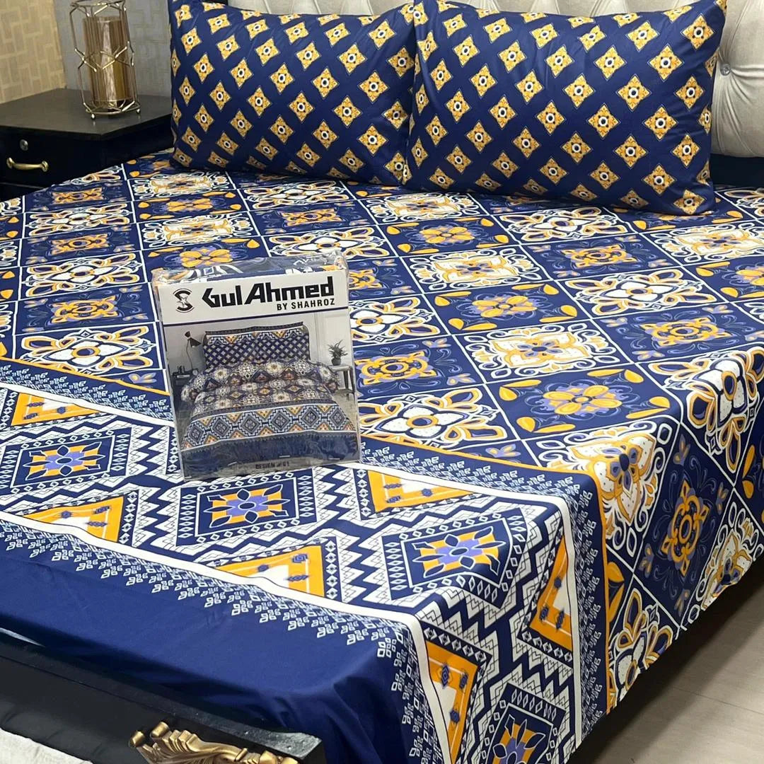 Bedspread with blue and yellow patterns on a bed, featuring Gul Ahmed branding.
