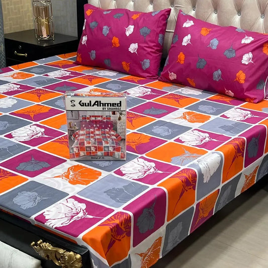 Colorful checkered bedspread with floral patterns on a bed, featuring Gul Ahmed branding.