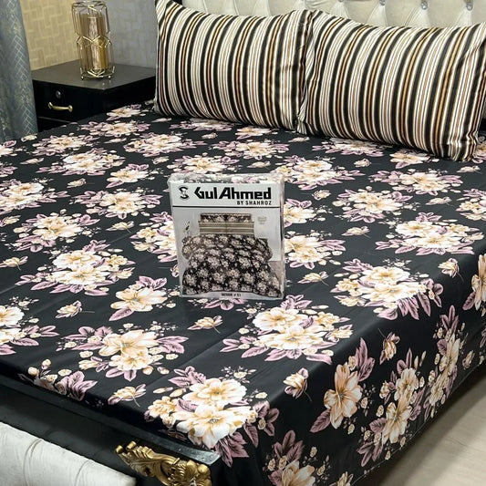 Floral patterned bedspread on a bed with a visible brand logo.
