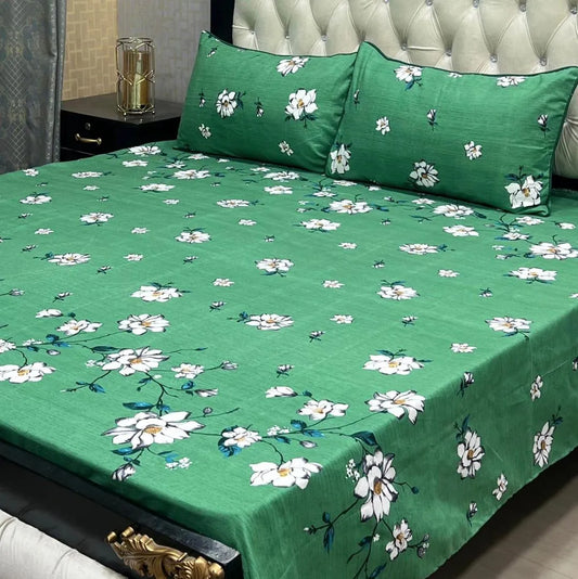 Green floral bedspread on a bed with matching pillows.