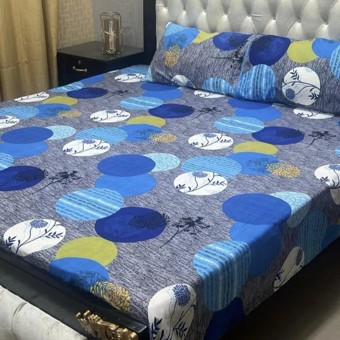Blue and gray patterned bedspread on a bed with matching pillows.