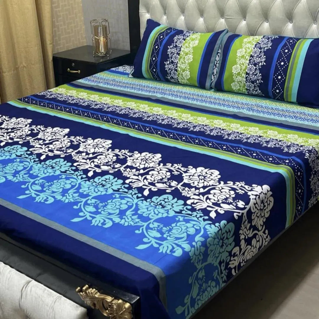 Blue and green floral patterned bedspread on a bed with matching pillows.
