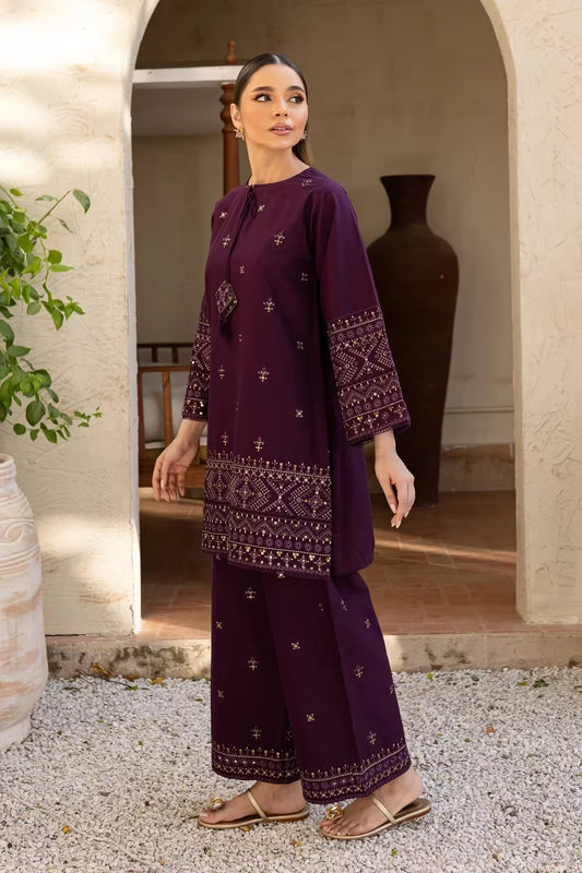 Woman in a purple traditional outfit standing in a sunlit outdoor setting.