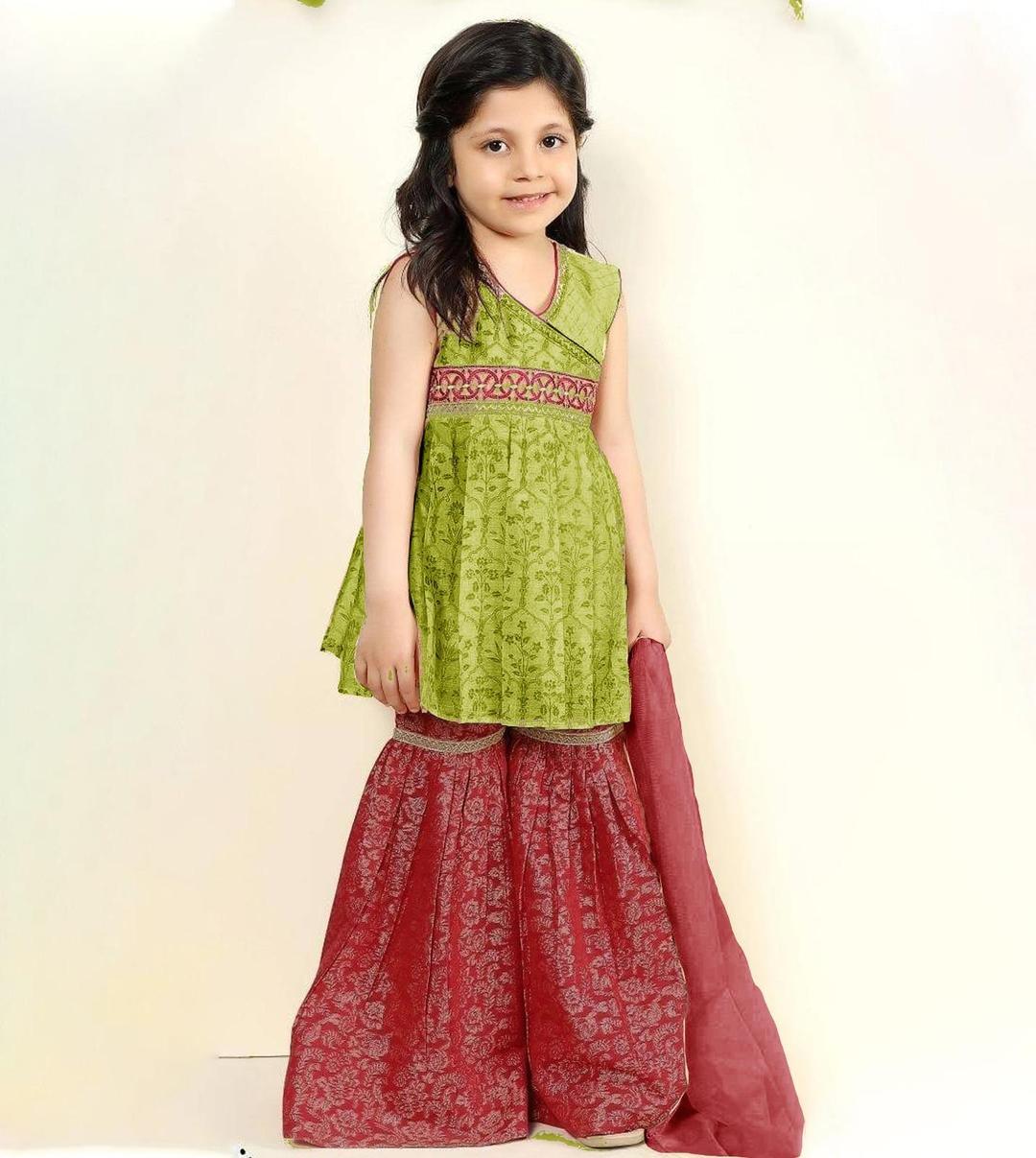 Young girl wearing a green top and red skirt with a white background