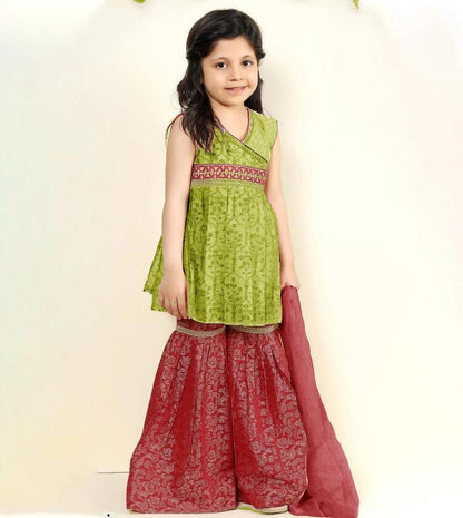 Young girl wearing a green top and red skirt with a white background
