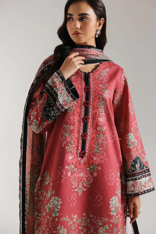 Woman wearing a red embroidered dress with a matching dupatta against a plain background