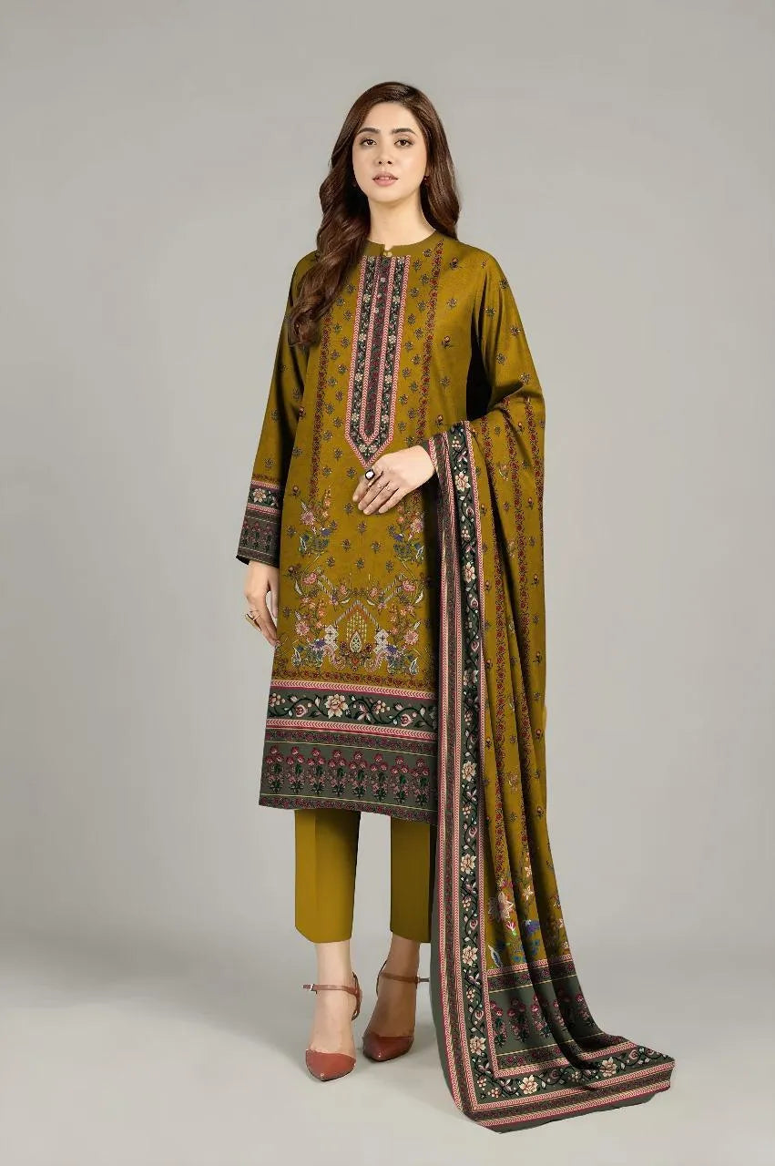 Woman wearing a green embroidered outfit with a matching dupatta on a gray background