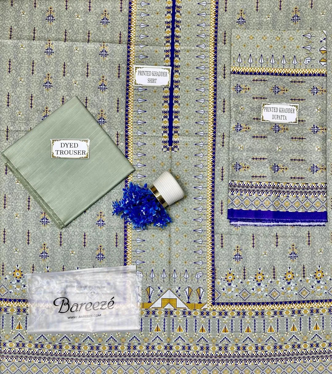 Patterned fabric with a green pocket square and decorative elements on a matching background.