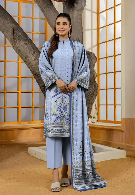 Woman wearing a light blue traditional outfit with a matching dupatta in a decorative setting.