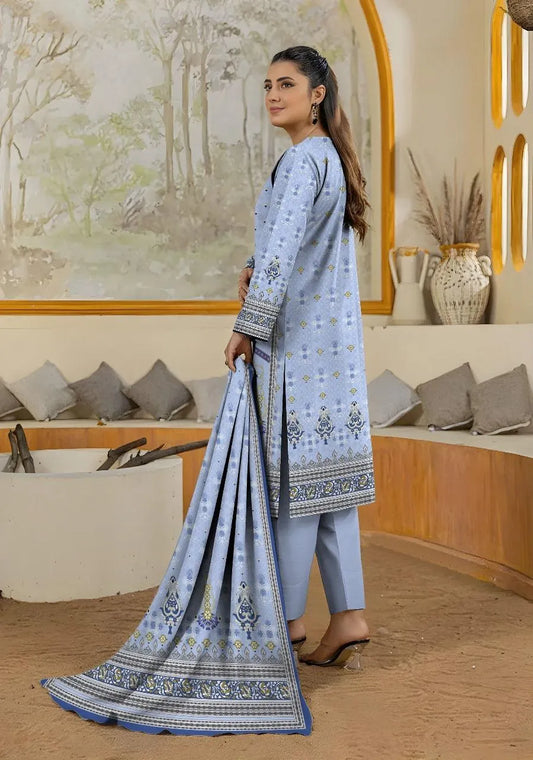 Woman holding a blue embroidered saree in a decorated room.