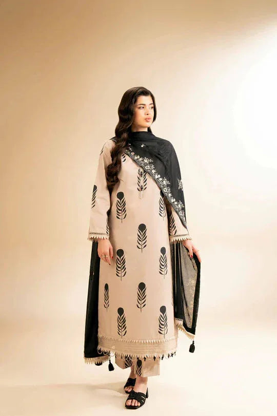 Woman wearing a beige and black traditional outfit with a matching scarf on a beige background