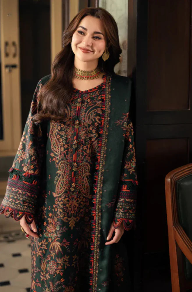 Woman wearing a traditional outfit with intricate patterns indoors.