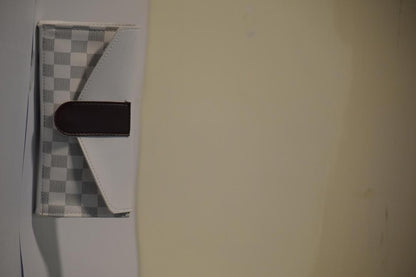 Small checkered mat with a black object on a light-colored floor