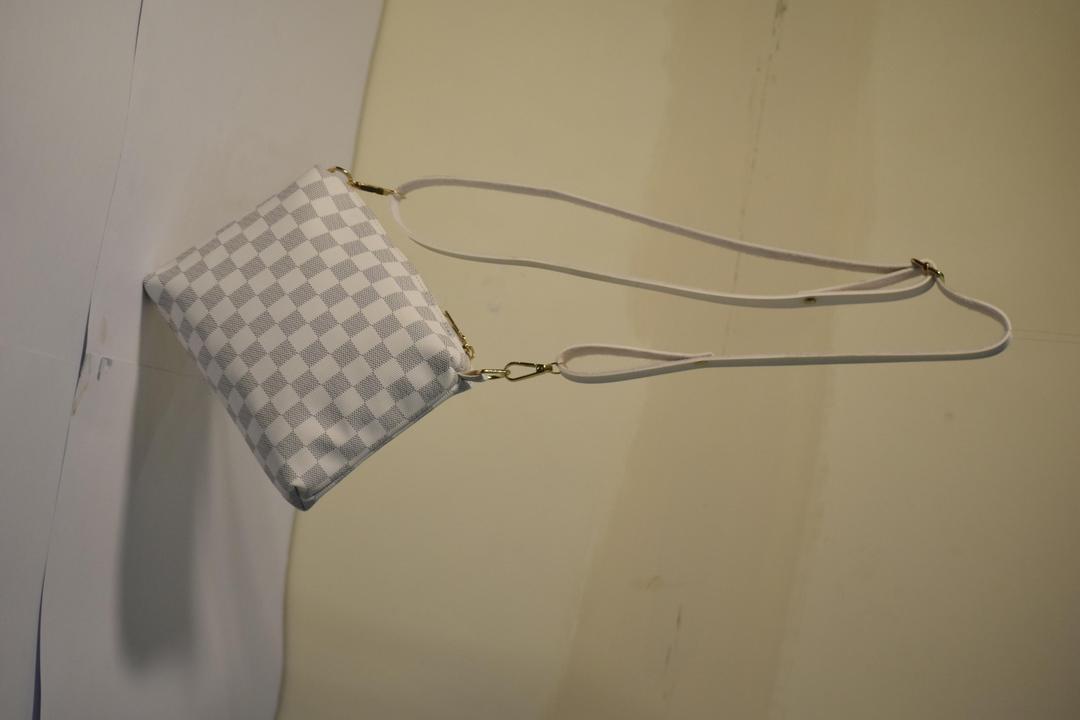 Checkered handbag with a strap on a plain background