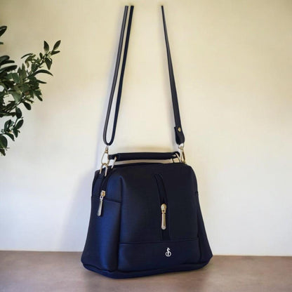 Black handbag with a plant in the background