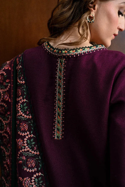 Close-up of a person wearing a dark purple garment with intricate embroidery on the back.
