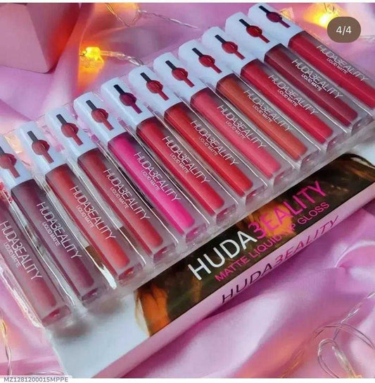 Set of Huda Beauty lip glosses in packaging on a pink background