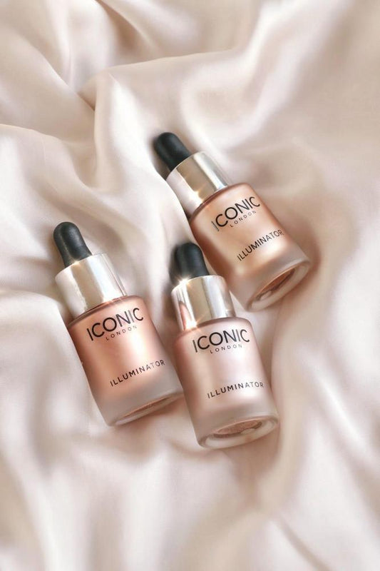 Three Iconic skincare bottles on a soft beige fabric background