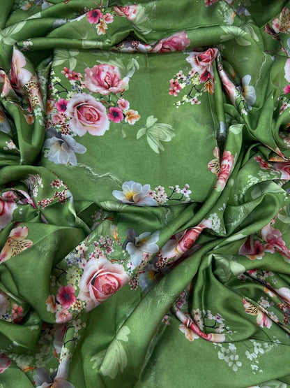 Green fabric with floral patterns, including roses and leaves.