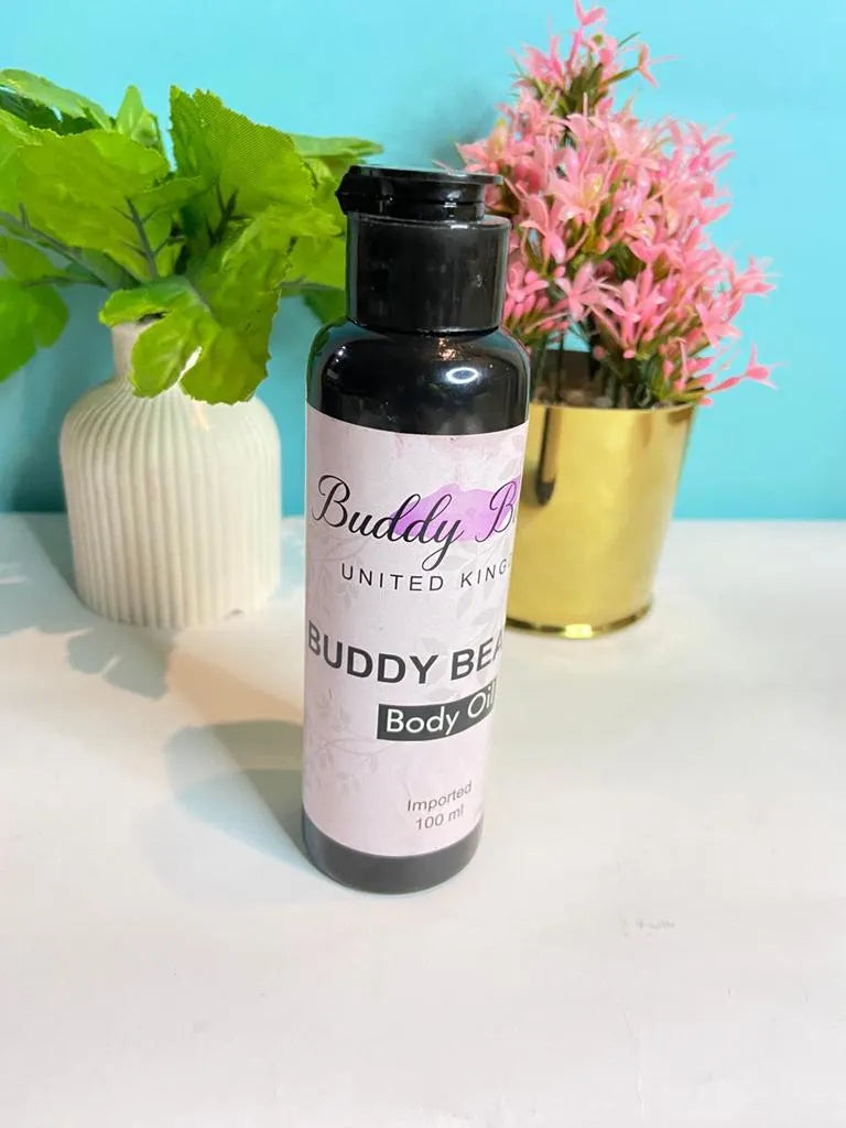 Bottle of Buddy Bee body oil on a white surface with plants in the background