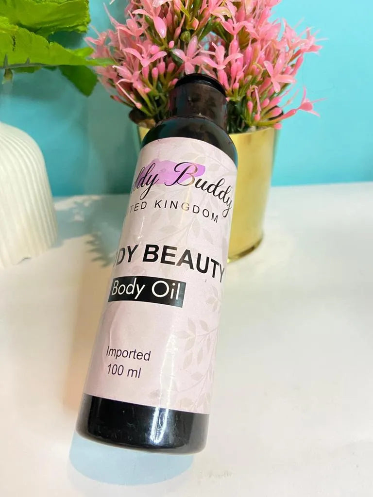 Body oil bottle with a pink label on a white surface with a blue background and pink flowers.