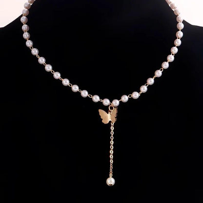 Pearl necklace with a gold butterfly pendant on a black background