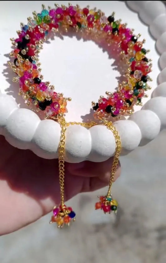 Colorful beaded bracelet and earrings on a white surface