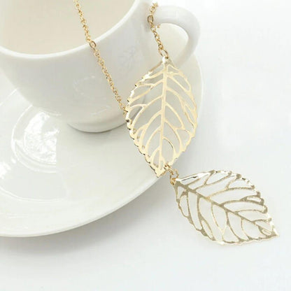 Gold leaf necklace on a white cup and saucer
