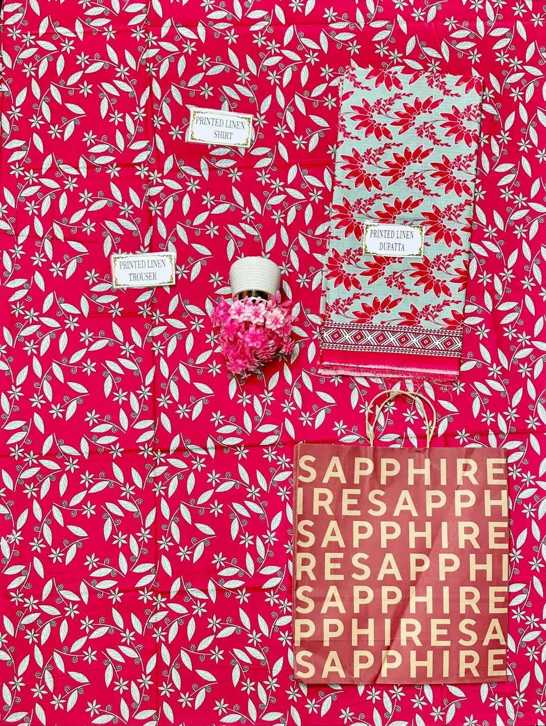 Product packaging with floral pattern and 'Sapphire' branding on a pink background