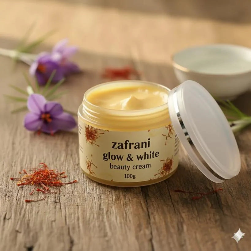 Jar of zafrani glow & white beauty cream on a wooden surface with saffron and flowers.