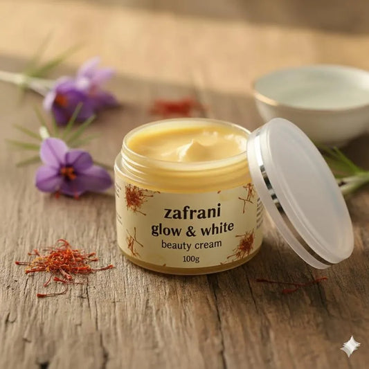 Jar of zafrani glow & white beauty cream on a wooden surface with saffron and flowers.