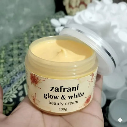 Jar of 'zafrani glow & white beauty cream' held by a hand with a blurred background