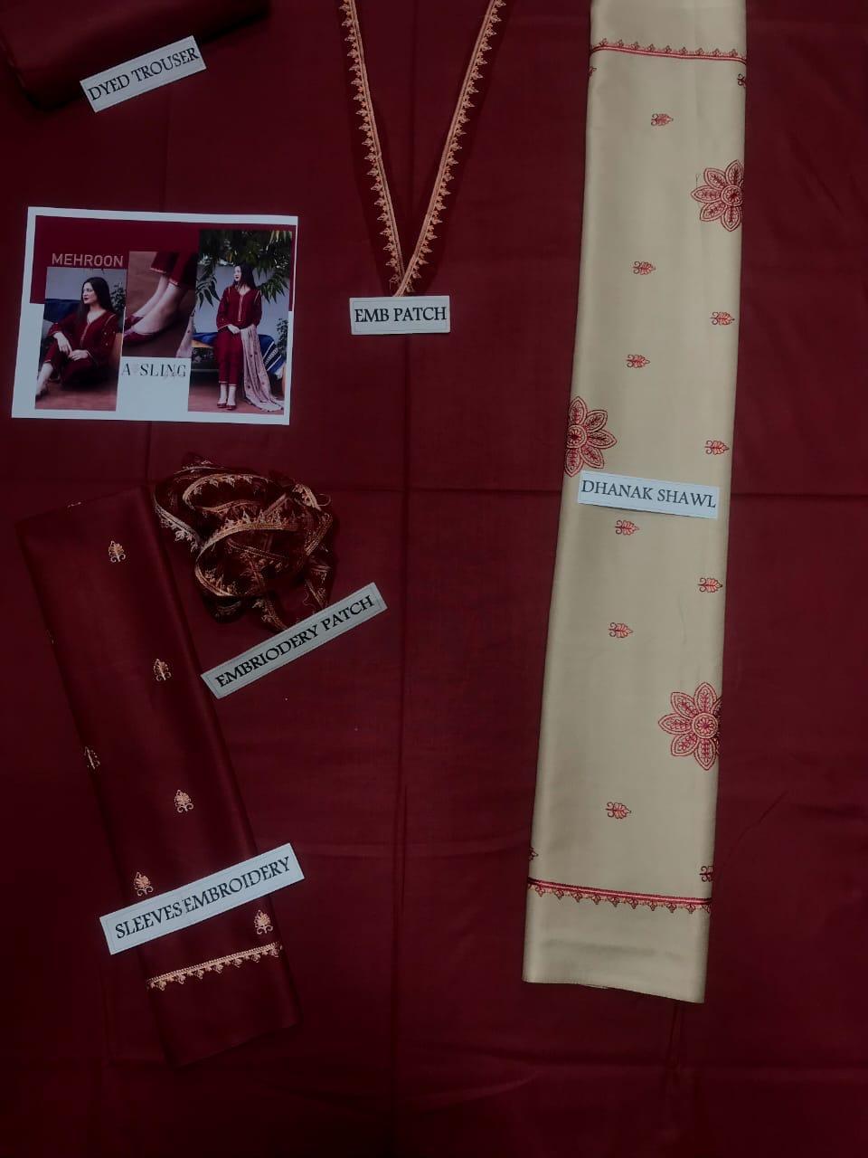 Red fabric with embroidered patches and a beige dhanak shawl on a matching red background.