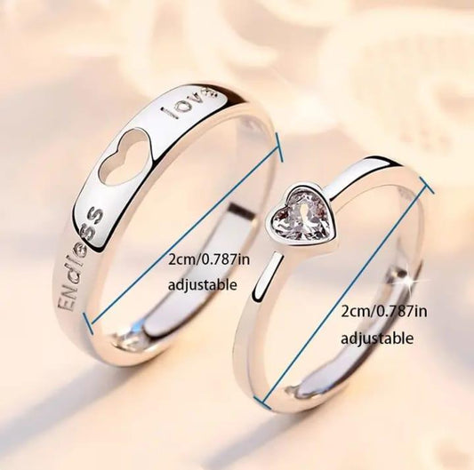 Two silver rings with heart designs and measurements on a light background