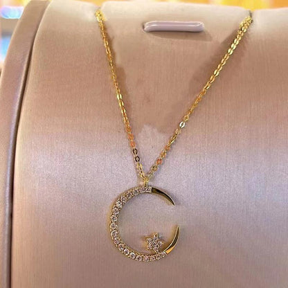 Gold necklace with a crescent moon and star pendant on a pink cushion