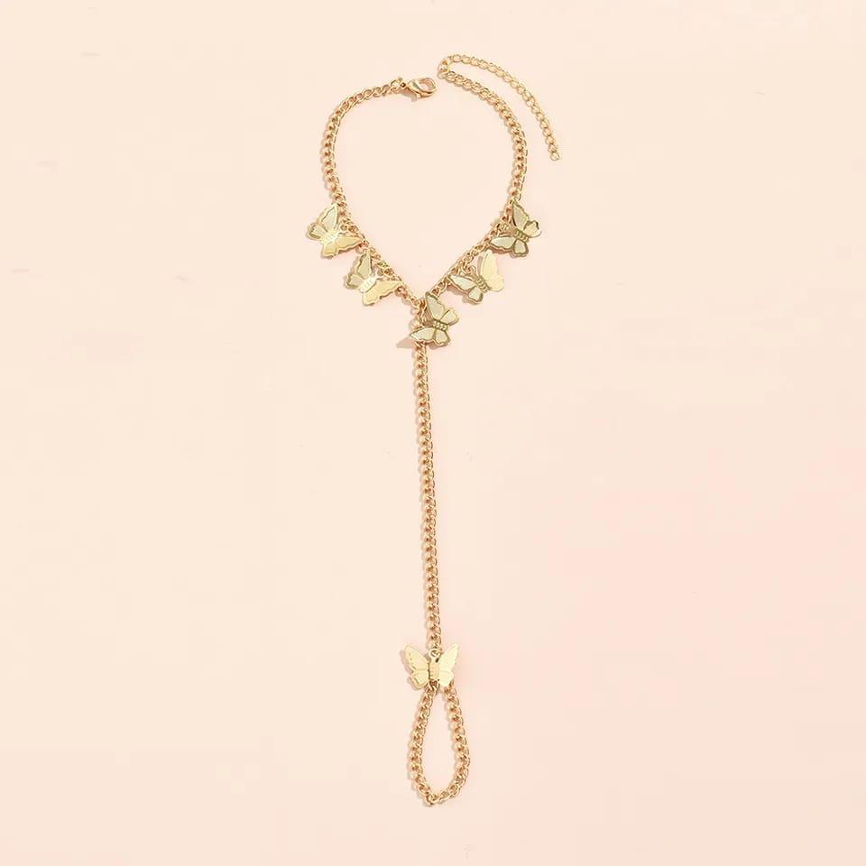 Gold necklace with butterfly pendants on a light pink background