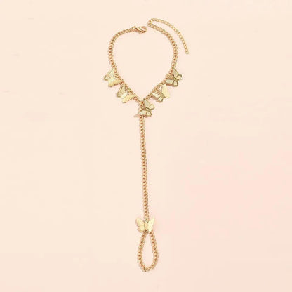 Gold necklace with butterfly pendants on a light pink background