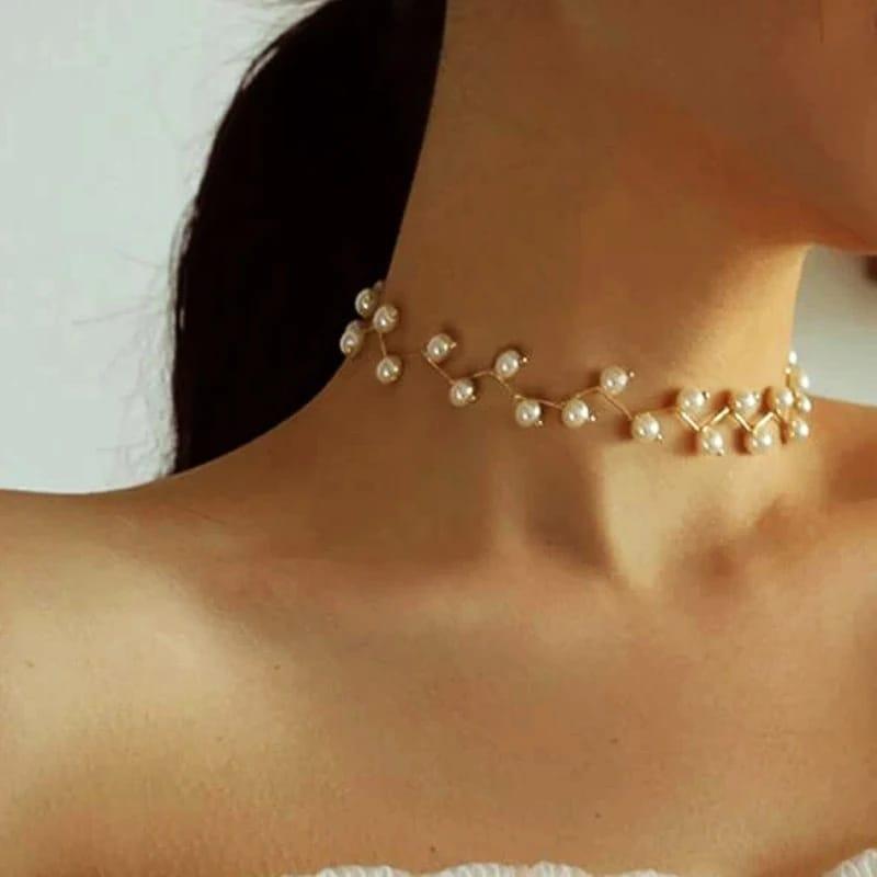 Pearl choker necklace worn by a person with a neutral background